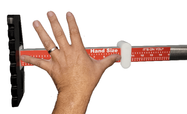 Hand using a hand size measuring tool.