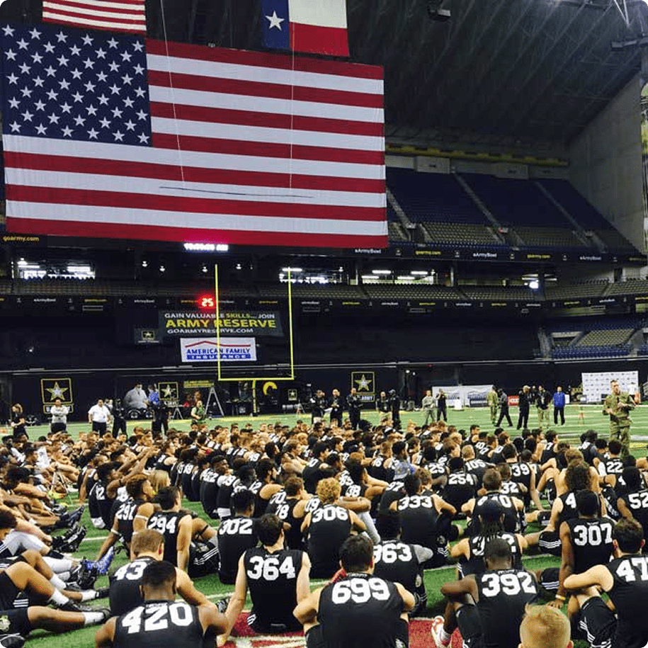 Football players gathered under large American flag.