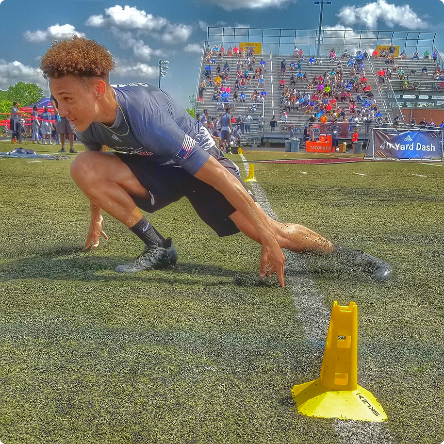 Athlete sprinting through agility course outside.