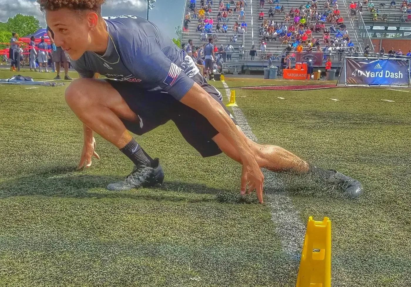 A man crouching down next to an obstacle course.