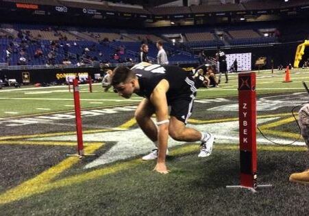A man running on the field with poles.