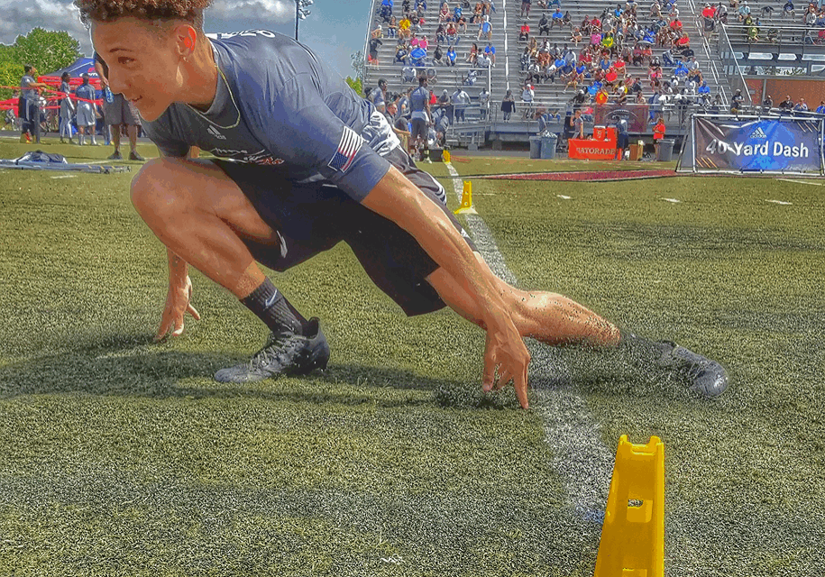 Athlete sprinting through agility course outside.